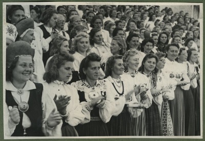 XII üldlaulupidu 28.-29. juunil 1947, Tallinnas.
Rahvariietes, sõlgedega ehitud naiskooride lauljad esinemas 12. üldlaulupeol Tallinna lauluväljakul. Taga paistab osa Tallinna vana laululava seinast.  duplicate photo