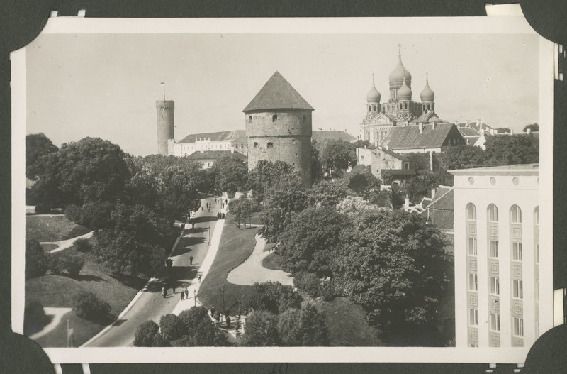 Vaade, Tallinn. Vaade Tallinna vanalinnale Jaani Kiriku tornist (?). Paremal paistab Harjumägi, Toompea loss ja Pika Hermanni torn, mille tipus lehvib Eesti lipp. Keskel Kiek in de Kök, sellest paremal Aleksander Nevski katedraal. Täiesti paremas nurgas paistab Vabaduse väljakul asuva EEKS maja nurk. Komandadi teel jalutavad inimesed.