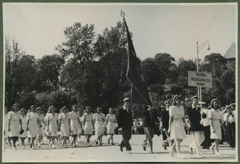 XII üldlaulupidu 28.-29. juunil 1947, Tallinnas.
Tallinna akadeemilised koorid 12. üldlaulupeo rongkäigul Vabaduse väljakul. Eesreas lipukandjad, tagant liiguvad järgi valgesse riietatud naiskoori lauljad.