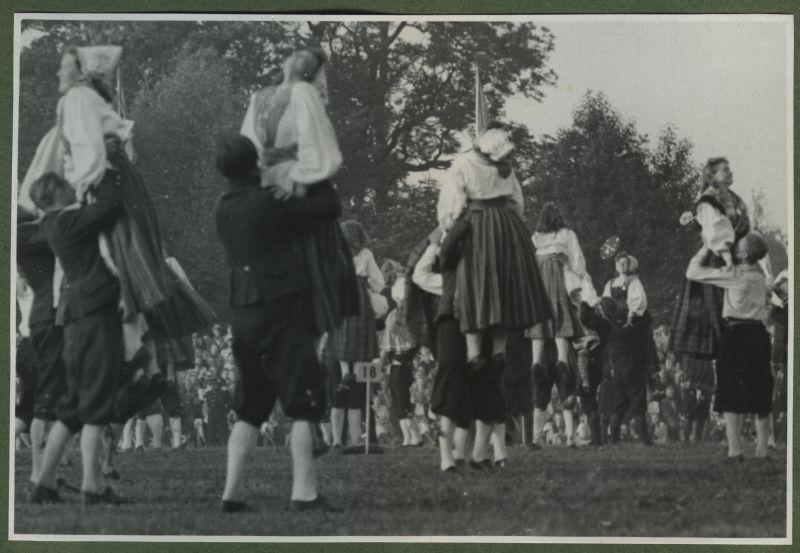 XII üldlaulupidu 28.-29. juunil 1947, Tallinnas.
Rahvariietes rahvatantsijad esinemas rahvakunstiõhtul 12. üldlaulupeo eelõhtul Kadrioru staadionil. Segarühma tantsijad on koondunud paaridesse, fotole on jäädvustatud tõste, kus noormehed hoiavad neidudel pihast ja tõstavad nad üles.