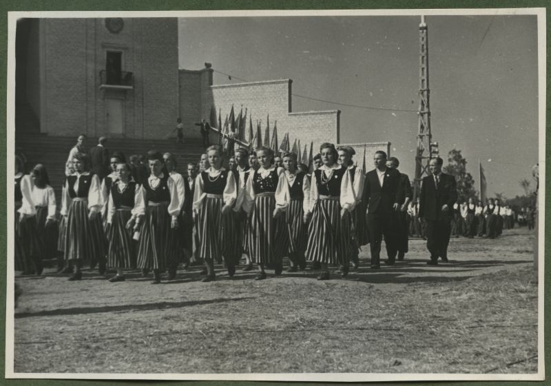 XII üldlaulupidu 28.-29. juunil 1947, Tallinnas.
12. üldlaulupeo osalejad rongkäigul jõudmas Tallinna lauluväljakule. Esimeses kahes reas rahvarõivastes naised, tagumises kahes reas ülikondades mehed. Tagapool paistavad järgmised laulupeoliste rühmad. Taustal Tallinna vana laululava, mis on ääristatud erinevate lippudega.