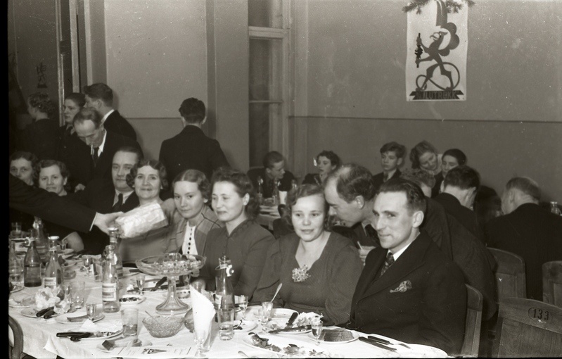 Inimesed peolaudade ääres istumas (Trükikodade Mattiesen ja Ilutrükk ühine jõulupidu 23. detsembril 1938)