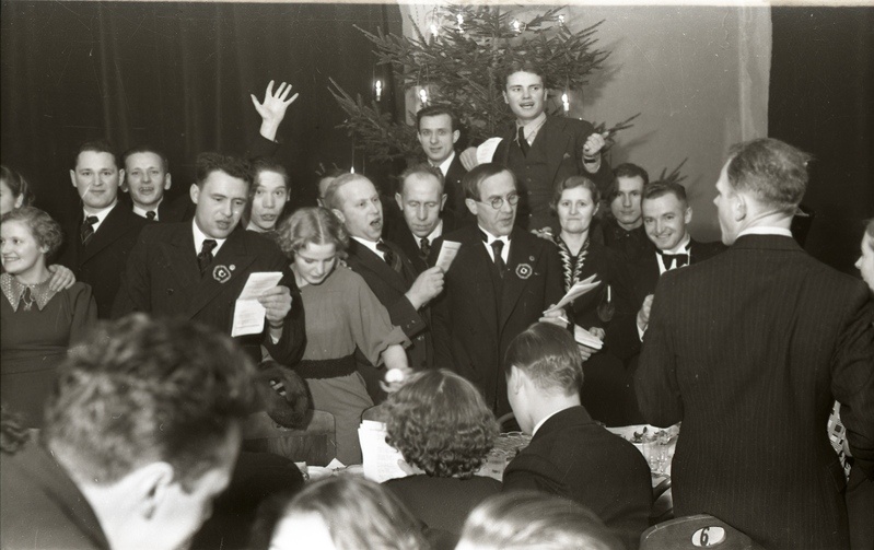 Seltskond laulmas jõulupuu taustal (Trükikodade Mattiesen ja Ilutrükk ühine jõulupidu 23. detsembril 1938)