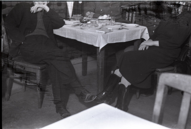 Inimesed laua taga istumas, kaader pisut kraabitud/soditud (Noor-Eesti kirjastuse jõulupidu 18. detsembril 1938)