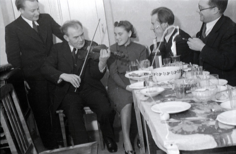 Heino Eller viiulit mängimas ning kolm meest ja naine teda kuulamas