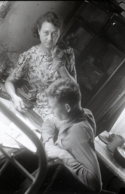 Elmar Kaldi abikaasa Ida Kald kassiga ja poeg Taevo Kald kirjutuslaua taga istumas  similar photo