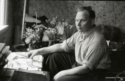 Mees ajalehega väikse laua ees istumas  similar photo