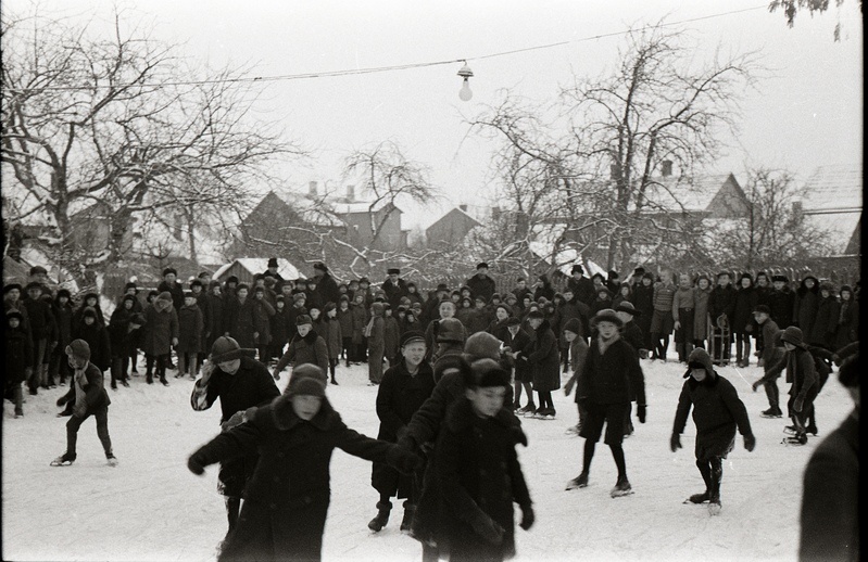 Poeglastekooli õpilased Tartu Peetri kiriku juures asuval liuväljal uisutamas ja uisuvälja ääres seismas