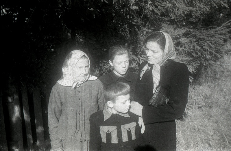Kaks naist ja kaks poissi aia taustal seismas