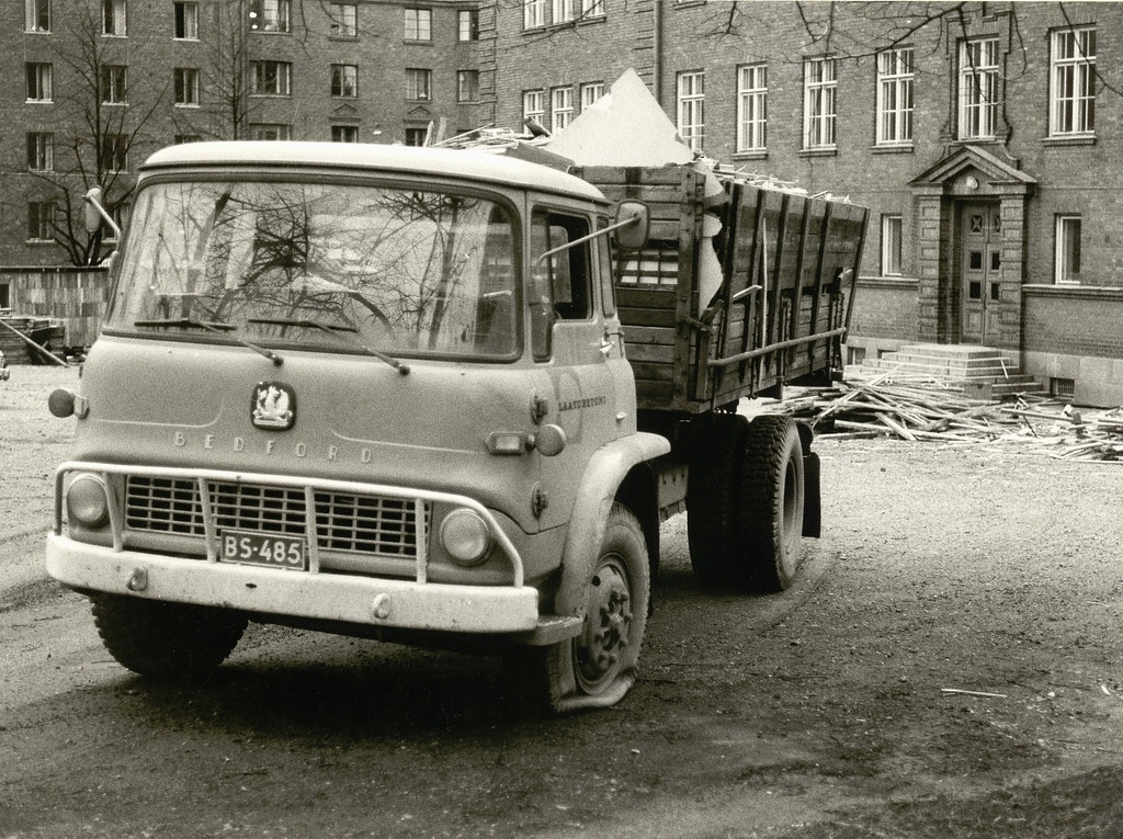 A truck with a broken wheel in front of the Chydenia building