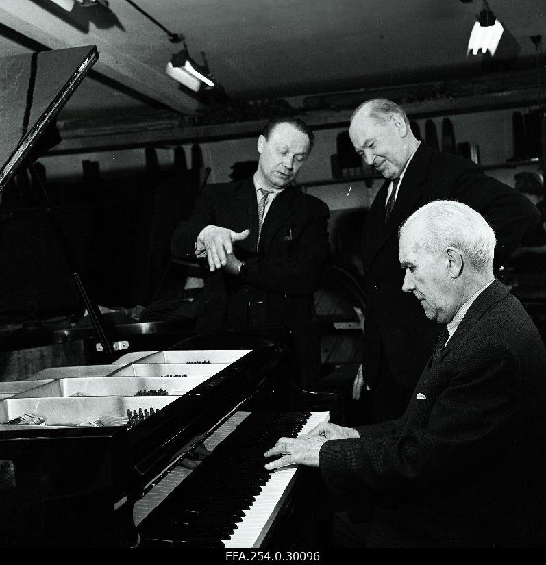 Professor Artur Lemba of the Tallinn National Conservatory is trying a new piano at the Tallinn Klaver factory. Behind the factory head artist a. Kurmet and chief engineer e. Võrk.