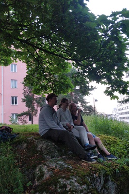 Kolme tyttöä istumassa kallioilla Katri Valan puistossa, takana Vilhonvuorenkuja 20. rephoto