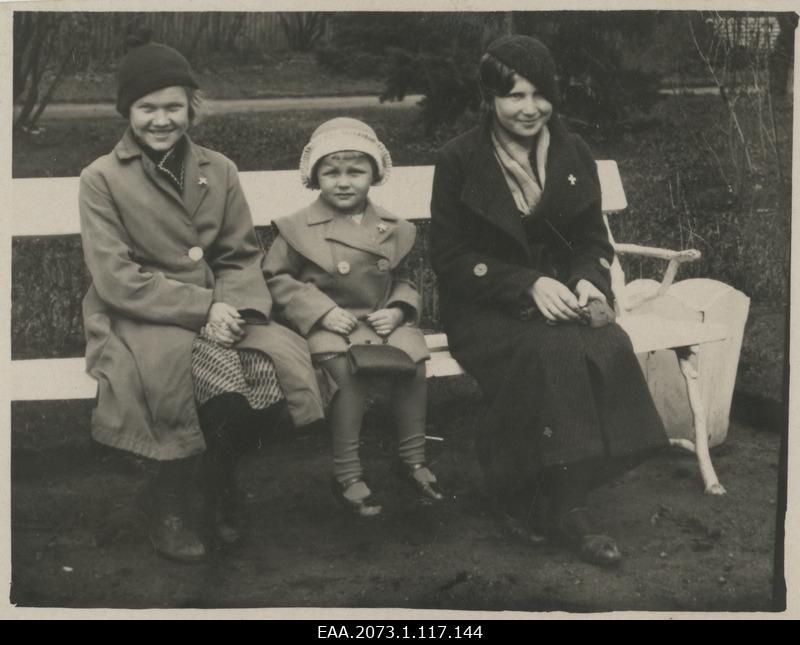 A woman with children sitting on the parking bench in Pärnu, with white crosses in all breasts