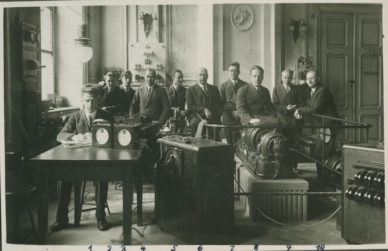 Foto albumist Tallinna Tehnikum. Tallinna Tehnikumi tugevvoolu laboratoorium Pikal tn., vasakult: 1) R. Hollman, 2) F. Heinmets, 4) D. Pärtelson, 5) V. Anvelt, 6) O. Reinvaldt, 7) V. Jaason, 8) V. Tamera, 9) M. Ernesaks, 10) A. Liefländer