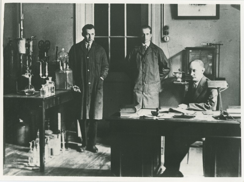 Tartu Ülikooli anorgaanilise keemia laboratooriumis, laua taga istub Paul Kogerman, seisavad J. Põllumann ja Hugo Raudsepp (paremal), 1932.a.