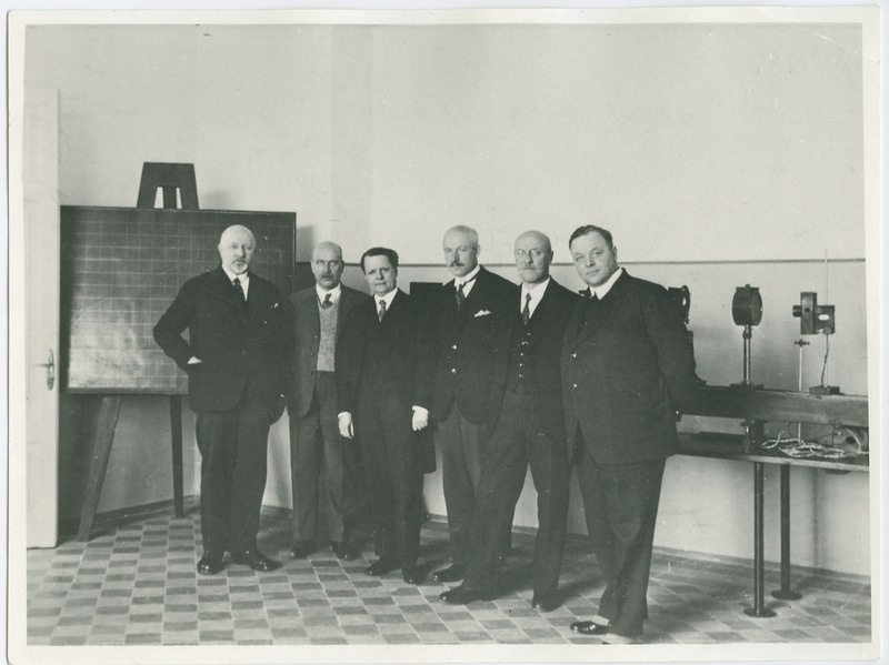 Tallinna Tehnikumi elektrotehnika labor, seisavad vasakult: 1) prof. O. Maddison, 2) prof. O. Reinvald, 3) väliskülaline, 4) ins. F. Petersen, 5) ins. E. Leppik, 6) väliskülaline, 1932.a.