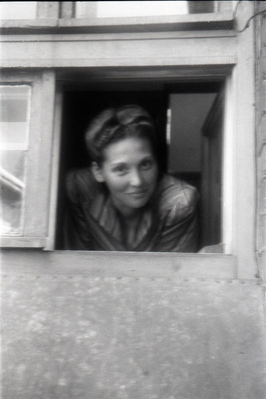 Naine väiksest aknast välja vaatamas