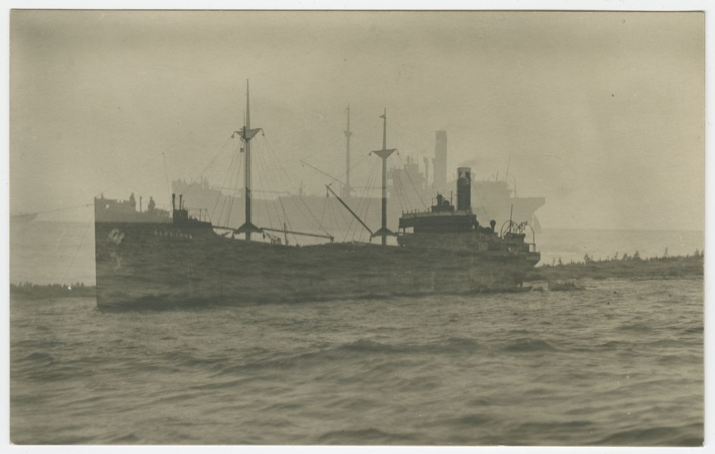 A steam ship that sailed the beach. The boat with men at the water at the boat's harbour.