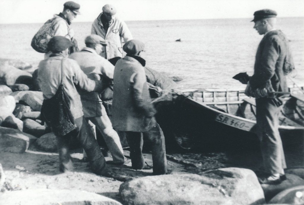 Fishermen pull the boat to the shore
