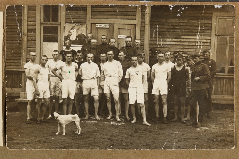 Lennuväe mundris ja spordirõivis mehed majaukse ees koeraga