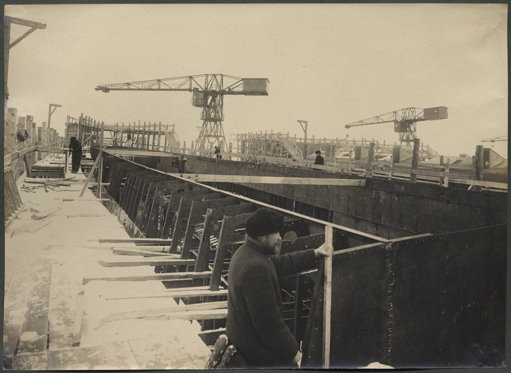 On the left of the Russian-Baltic shipyard.  At the forefront of elling with the body of the ship built and with the person. Behind the ellings and cranes