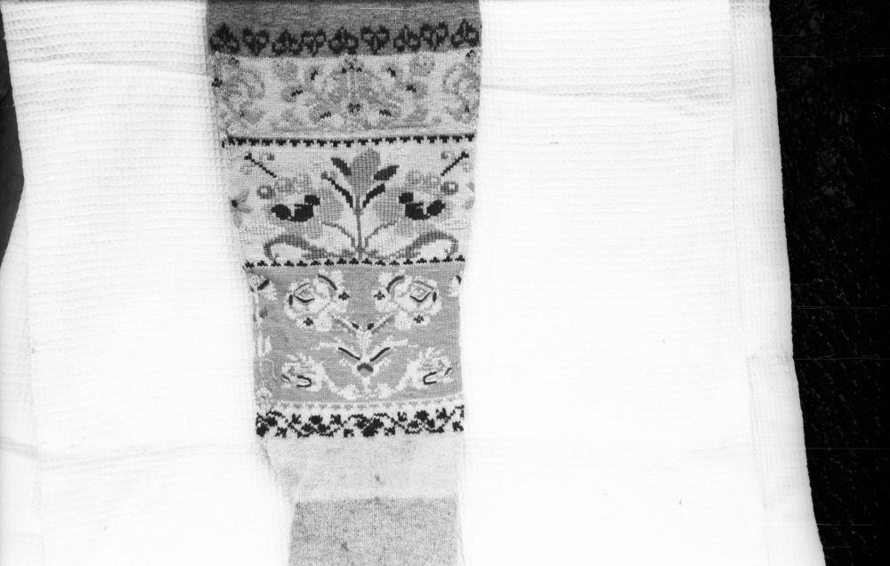 Kootud lillkirjadega sukk, detail.