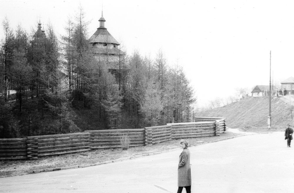 Lvovi vabaõhumuuseum, palkaed parkimisplatsi ääres ja puukirik.