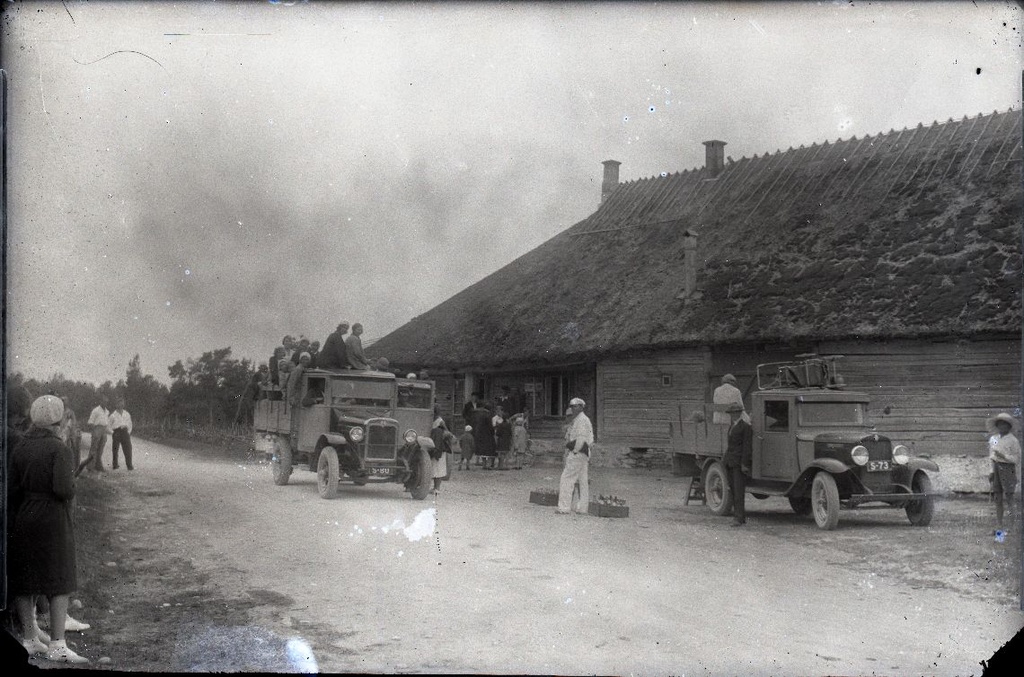 Tourists with cars on exit, cars in front of the farmhouse.