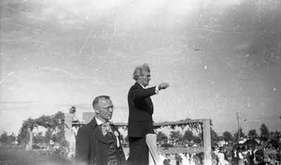 Juhan Simm dirigeerimas ja Richard Ritsing (vasakul) platvormil (laulupidu)?  similar photo