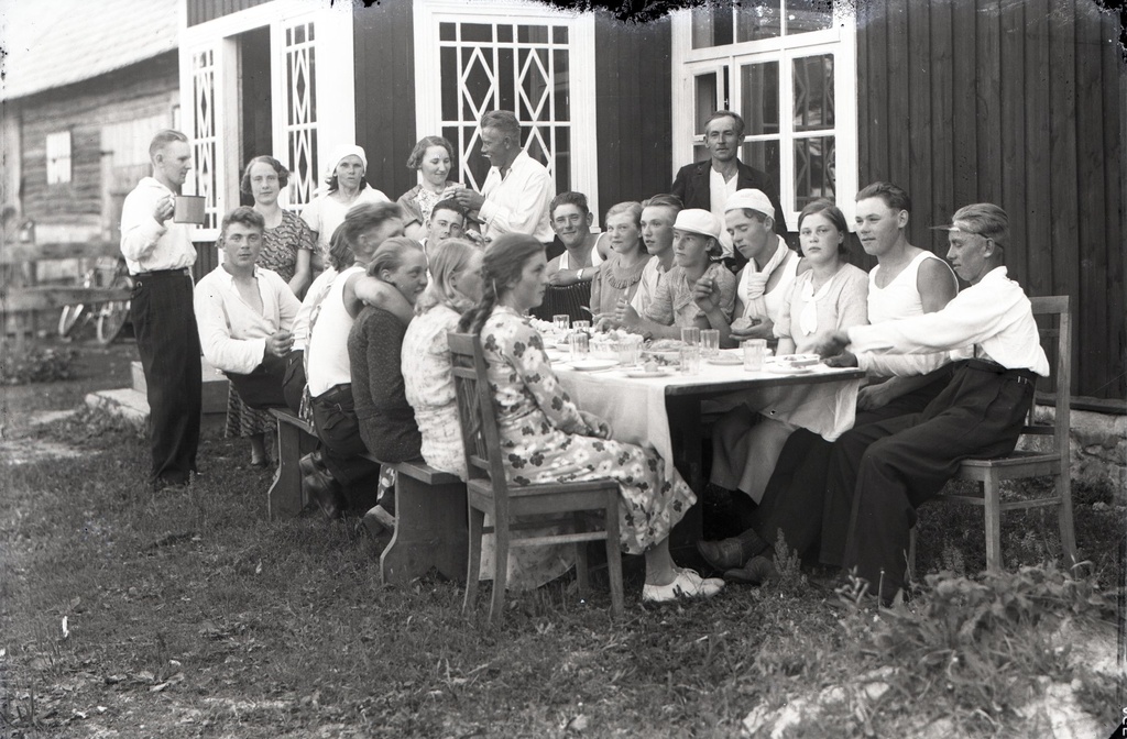 Seltskond maal elumaja ees söögi/pidulaua taga