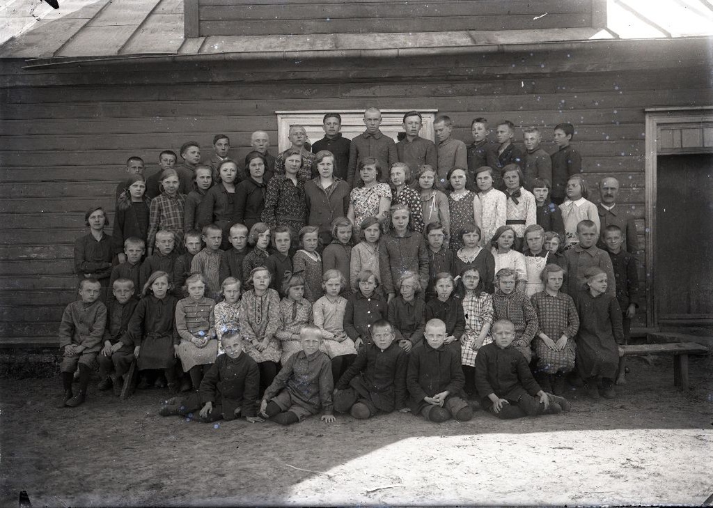 Õpilased koos õpetajaga koolimaja ees