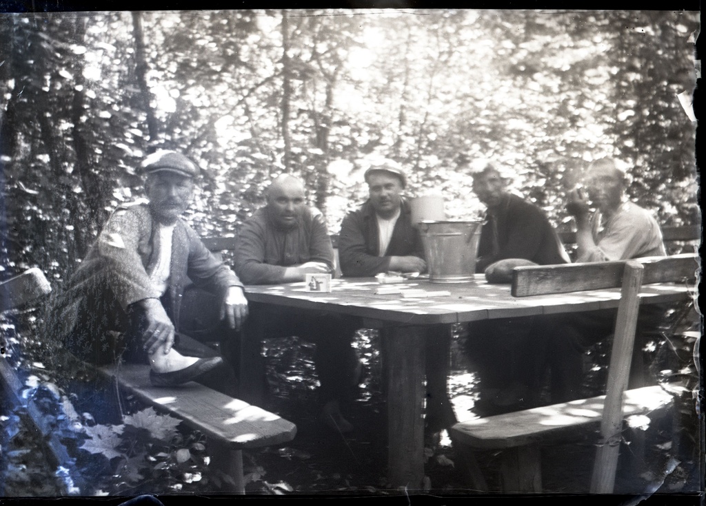 Mehed aias Aleksander Klaasi lehtlas õlleämbri ümber
