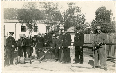 Tuletõrjujad käsipritsiga ühe maja hoovis  duplicate photo