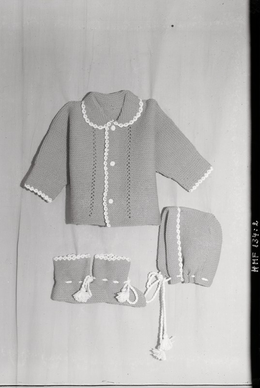 Tselluloidnegatiiv. Teeninduskombinaat "Haapsalu" silmkoe toodete näidised. 1968.
Imiku riided - kampsun (kolm nööpi), püksid (paelaga), jalatsid, paeltega.
