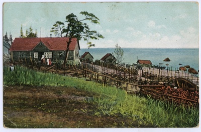 A small village. Fishing houses on sandy hills, behind the sea.  duplicate photo