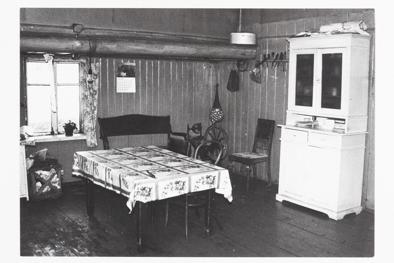 Vaade Jõe talu kööki, mis ümber ehitatud rehetoast. Söögilaud, puust sohva, söögikapp, toolid, vokk.