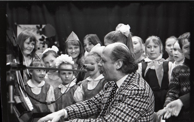 Kohtumine helilooja Gennadi Podelskiga, klaverit mängimas, taga lapsed