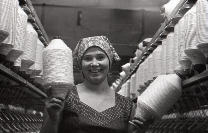 Komnoorte laupäevak ketrusvabrikus, naine kahe kedruse pooliga