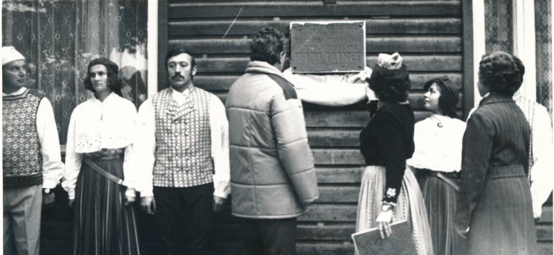 Foto.  Heljo Talmeti mälestustahvlilt eemaldavad katte (vasakult) Haapsalu Rajooni RSN TK esimehe asetäitja Lembit Kask, rahvatantsujuht Helgi Miller ja EKP RK II sekretär Laine Soosalu.  30.september 1982.a.
Foto: Tenno Sillaste.