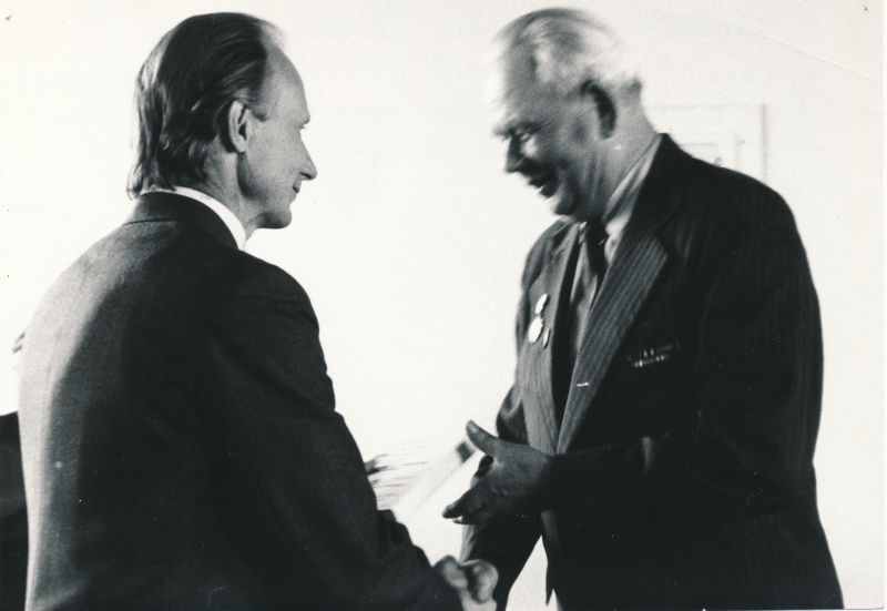 Foto. Vastuvõtul EKP Haapsalu rajoonikomitees 1981. a. Võidupühal. Elmu Peek annab mälestusraamatu veteran Friedel Joonasingile.  Mustvalge.