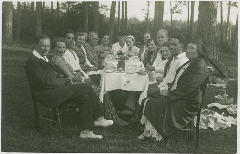 Foto. Piknikulised laua taga istumas. 1932.  Albumis HM 8466:1. Kuulunud kapten Harald Dampffile.