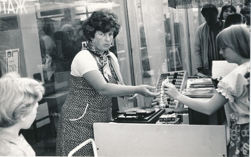 Foto. Kaubamaja kultuurikaupade sektsiooni müüja Elvi Benno juubelipidustuste aegses välimüügiletis, juuli 1979.a. 
Foto: Arvo Tarmula.