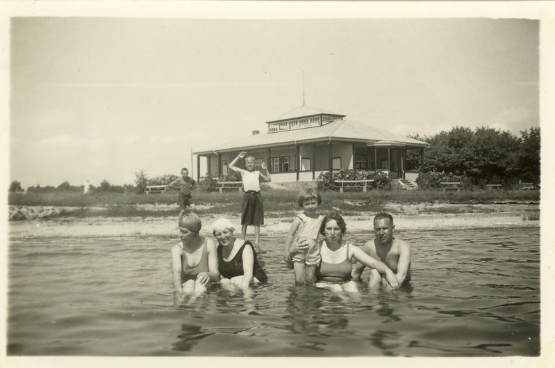 Kuressaare rand: vaade rannakohvikule. Esiplaanil suplejad meres. Paremalt: Gustav Rattur, Eevi Maria Rattur, laps Maie-Ly Haavel (Rattur). 1930. a. II pool.