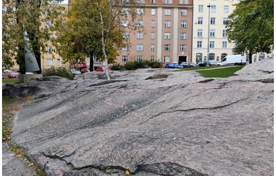 Oppilaita luokkakuvassa kallioilla Porthaninkadun varrella (nyk. Matti Heleniuksen puisto), taustalla Agricolankatu 9 ja 7 sekä halkopinoja. rephoto