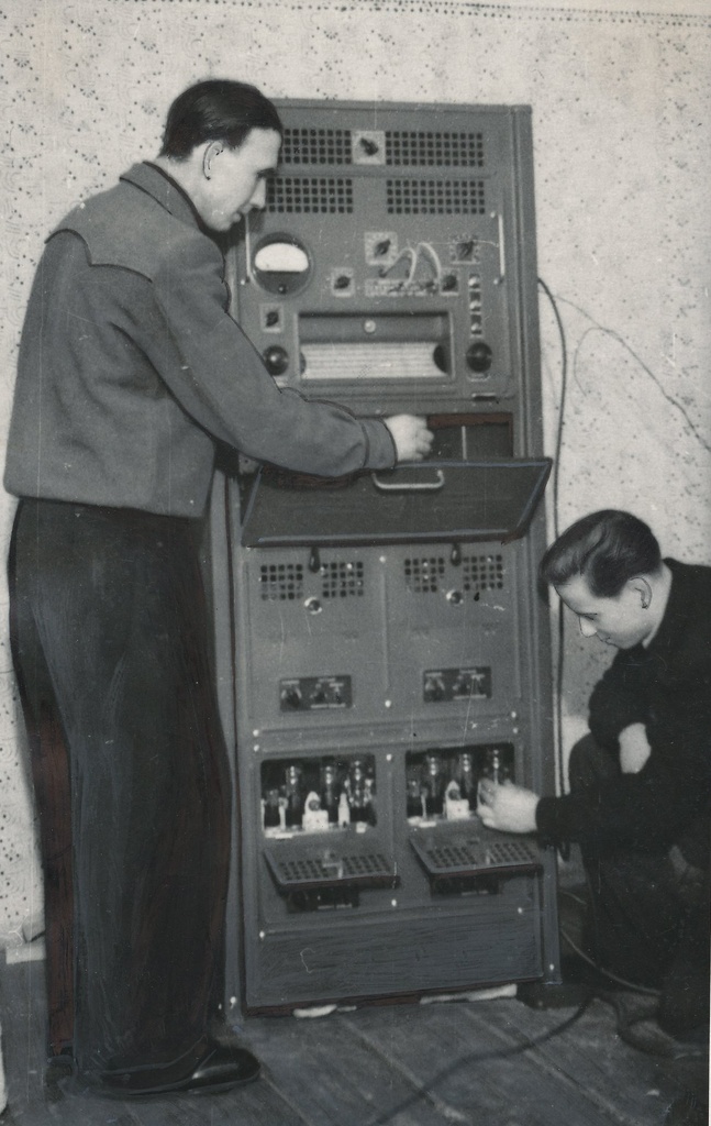 Foto. Orava MTJ elektrimontöör  Eino  Lehtla ja dispetšer-agronoom Raimond  Lübeck  translatsiooniseadeldise tööd kontrollimas 1956.a. veebruaris.
