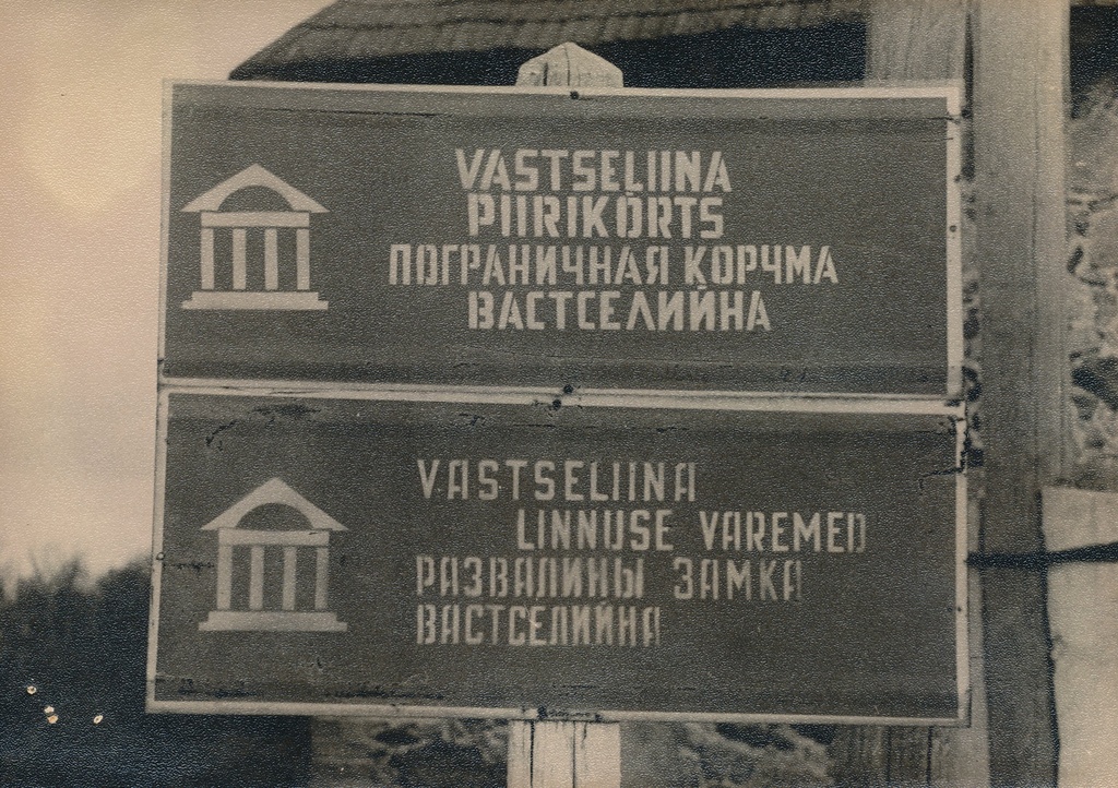 Fotoalbum. Vastseliina linnuse varemed. Vastseliina kõrtsi ees olevad teeviidad Piirikõrtsi ja linnuse kohta 1974.a.