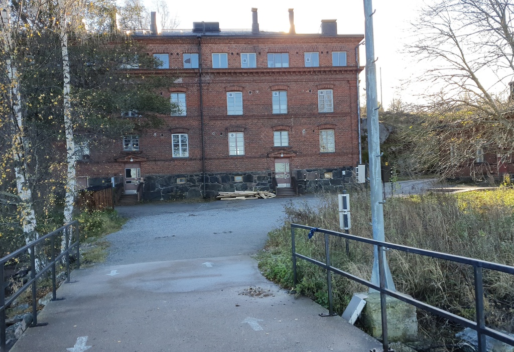 Vallisaaren luotsitalo päälaiturilta päin kuvattuna. Rakernnuksen edustalla oleva pieni puinen rakennus on vartiokoppi. Vallisaari oli pitkään ensin Venäjän armeijan varuskunta-aluetta, sitten itsenäistyneen Suomen armeijan aluetta, johon pääsy oli luvanvaraista. Vartiokopissa tarkastettiin kulkuluvat vielä 1960-luvun alkupuolella. rephoto