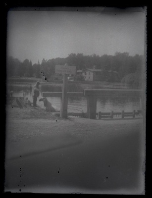 A man on the river, on the other side to see the house.  duplicate photo