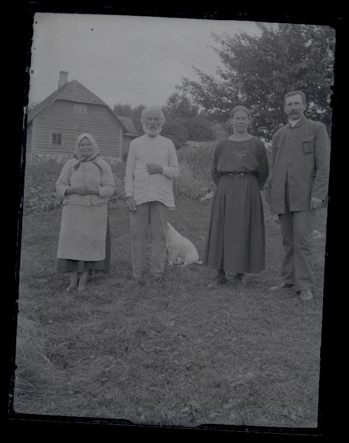 Four people and dogs, in the background to see a living house.