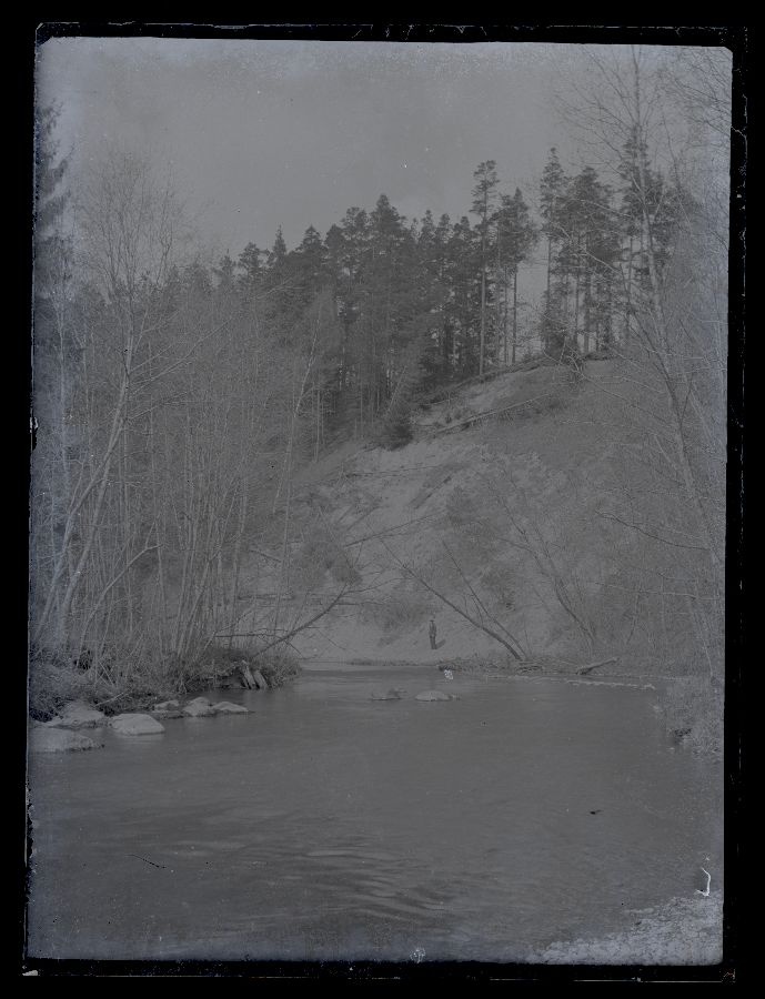 The view of the high shore river, the man stands on the river.